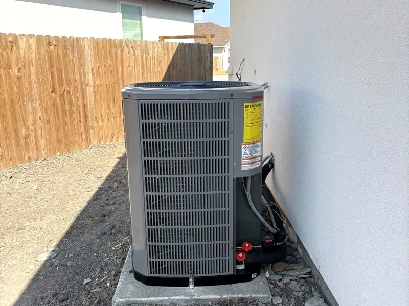 New American Standard outdoor unit on a concrete pad beside a new home, with the line set and disconnect neatly run