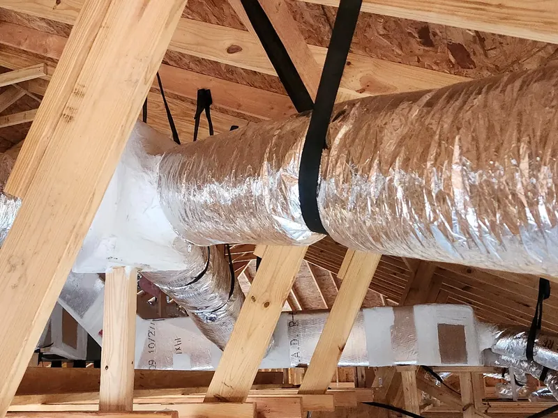 Large insulated duct junction box with branch runs, strapped up in an attic